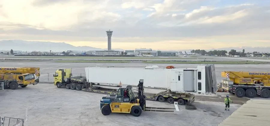 A new boarding bridge being unloaded on an airport apron