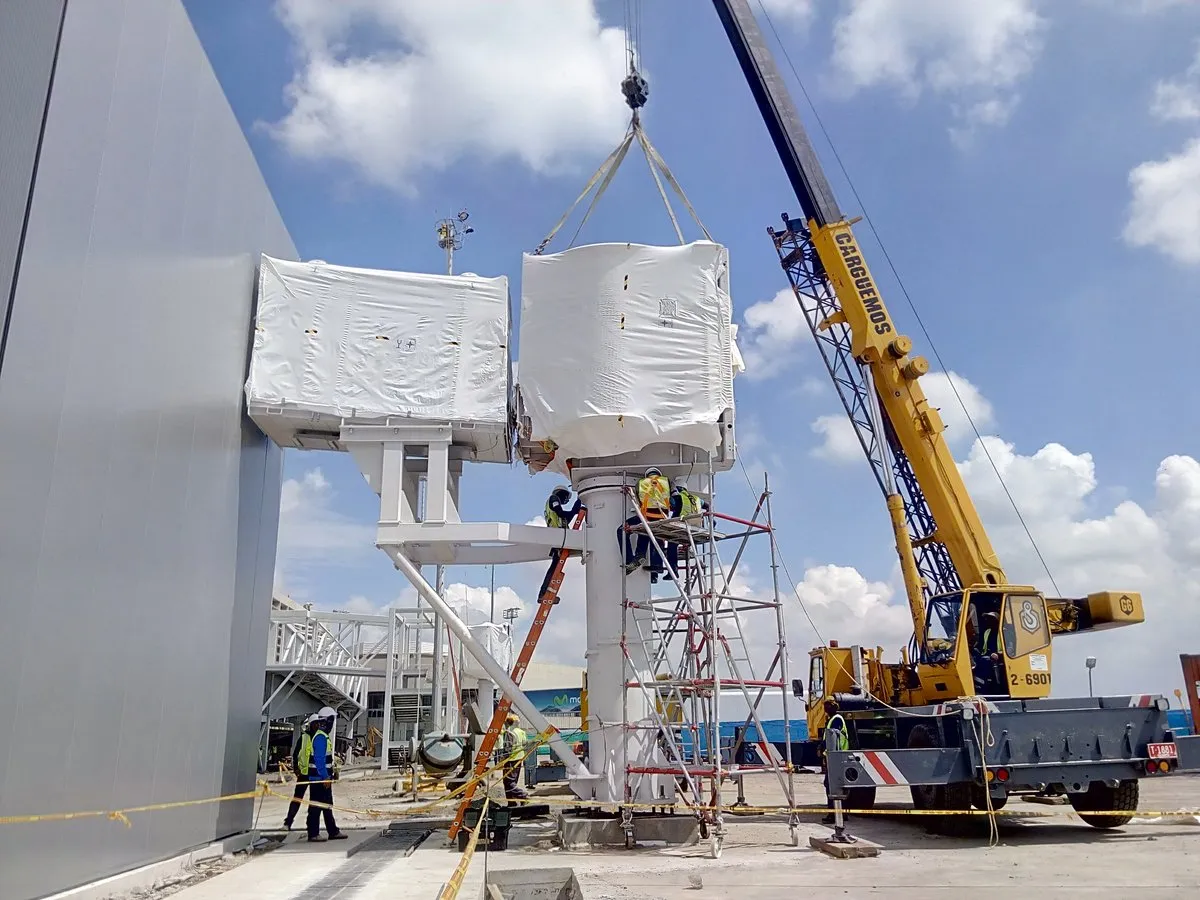 Crane lifting a boarding bridge module during installation at Cali airport, Colombia
