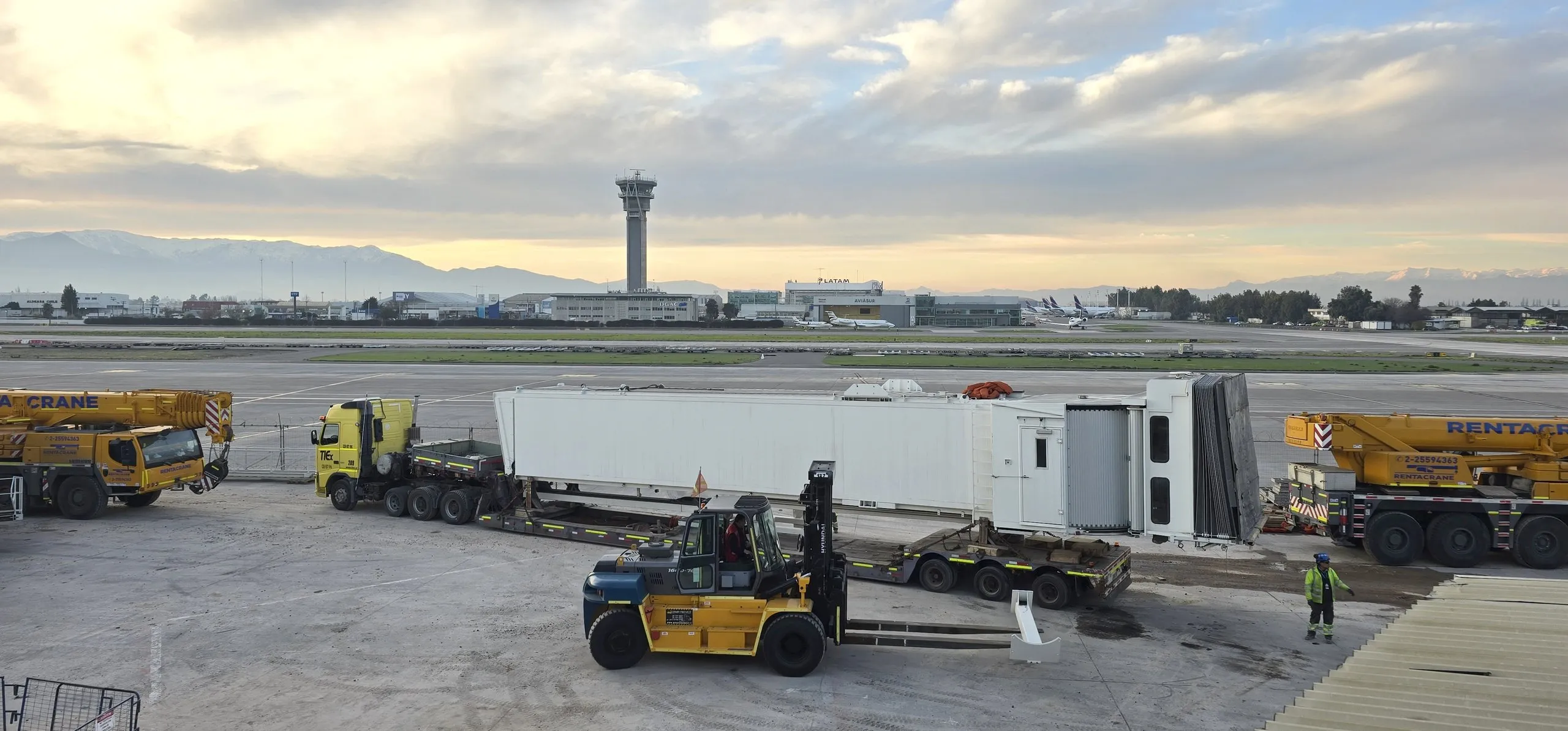 A boarding bridge being moved across the apron at an airport